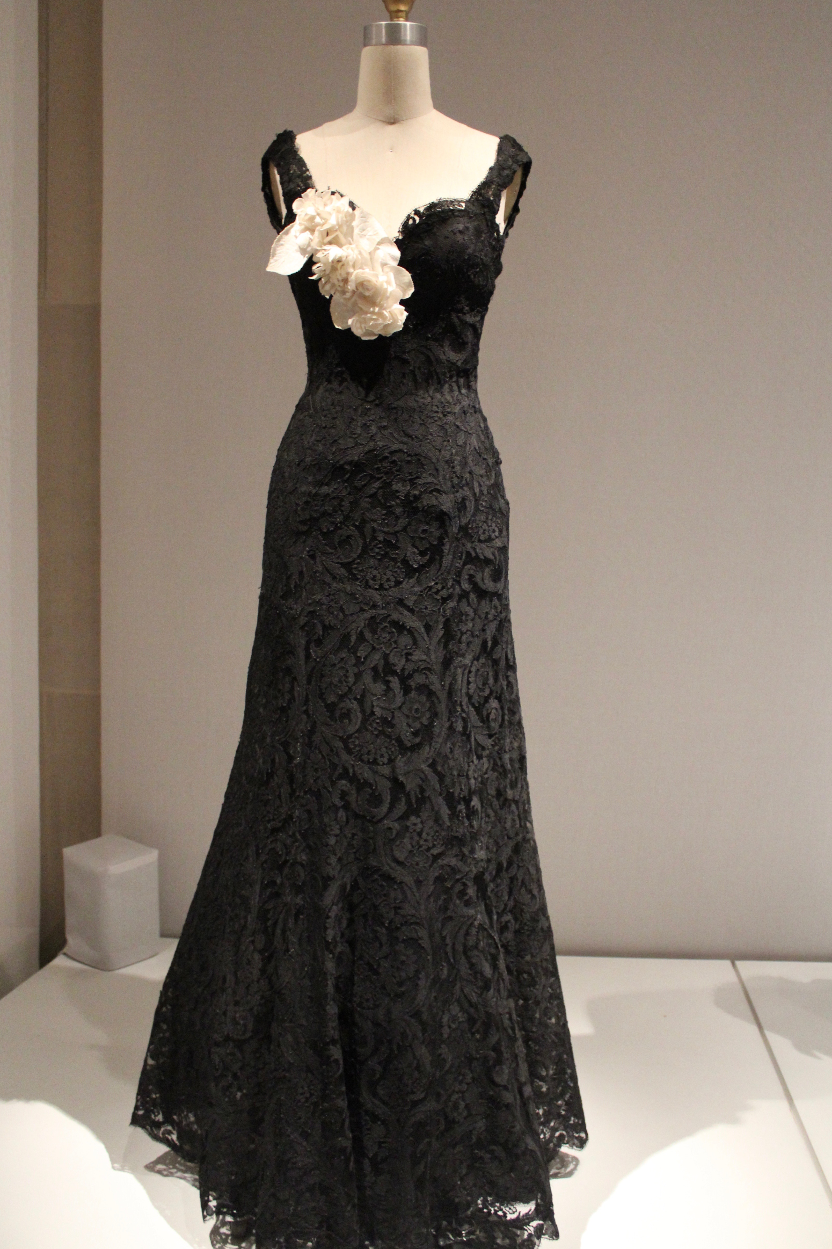 New York Calling: Manus x Machina, House of Chanel Evening Dress, 1937-1938, Haute Couture, Hand-sewn, machine-made black silk rayon lace, hand-shaped with wire and horsehair at sleeves; hand-attached, machine-sewn black rayon crepe liner; white linen floral corsage with die-cut, hand-embossed, and hand-assembled flowers.