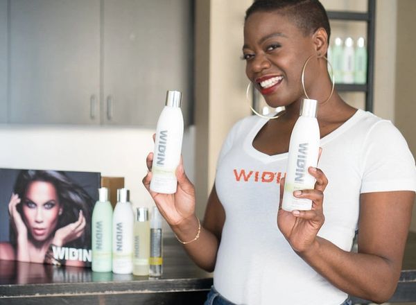 Shaneek Steele holding her WIDIN products for hair loss.