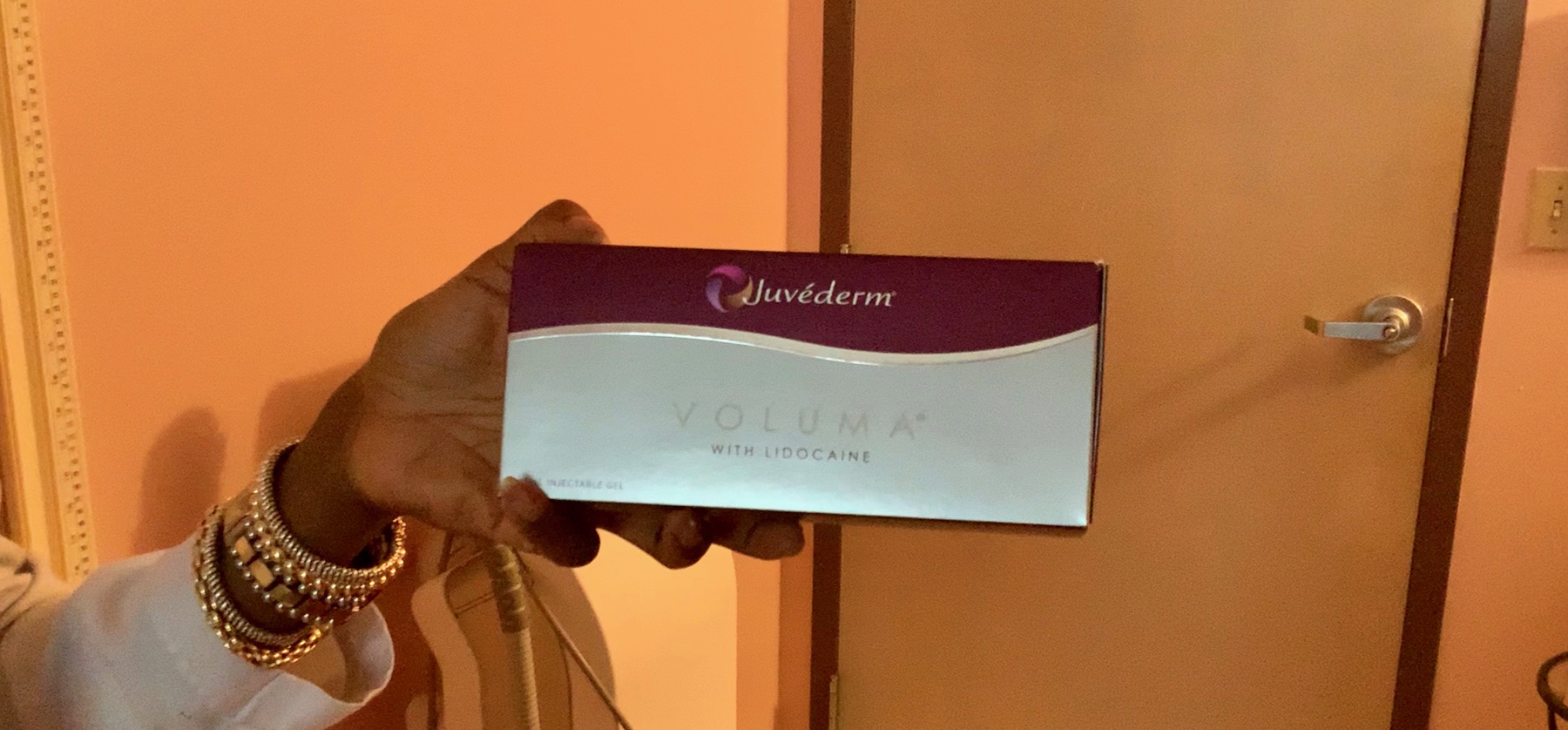 Dr. Claudette Jatto holding Box of Juvéderm